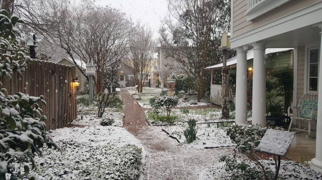 View of the snow-covered gardens at Hope and Glory Inn, one of the best places to visit in Virginia in Winter