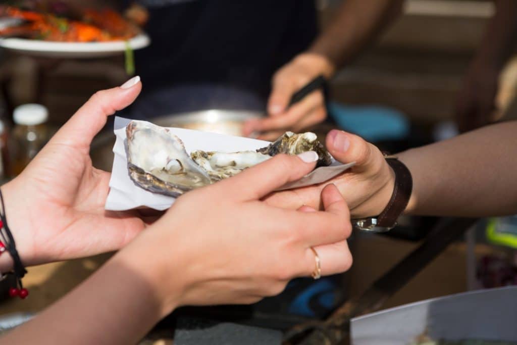 Someone holding a plate of oysters at the Deltaville Seafood Festival