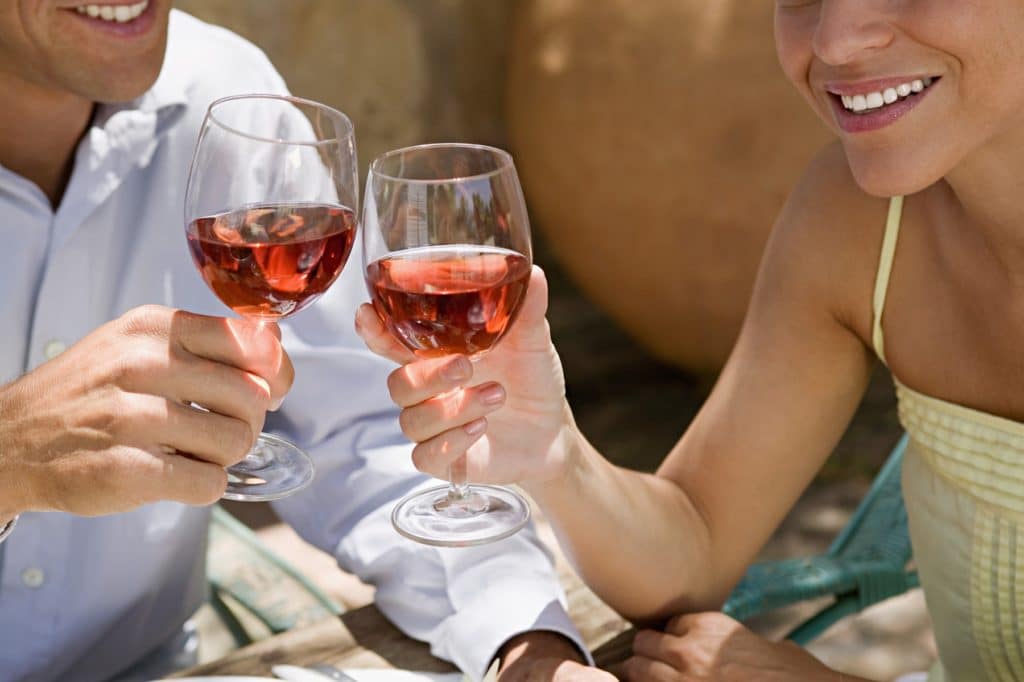 A man and woman holding wine glasses at Good Luck Cellars
