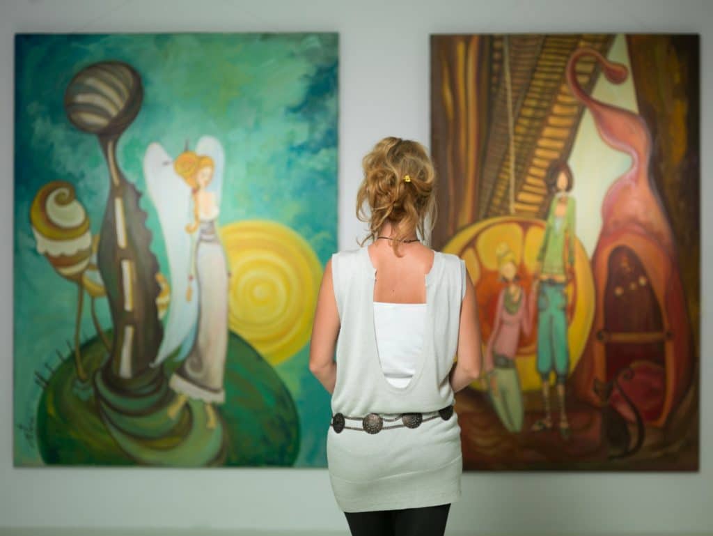 A woman viewing artwork at the Objects, Art and More gallery