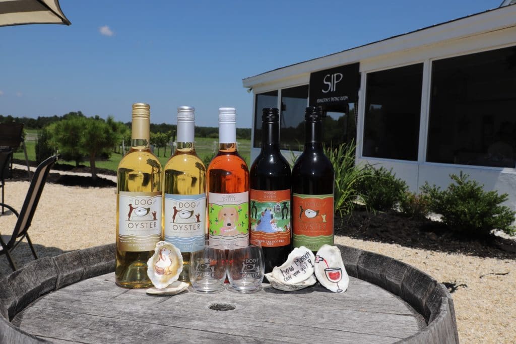 Bottles of wine, glasses, and oyster shells at The Dog and Oyster Vineyard for wine lovers' getaways in Virginia