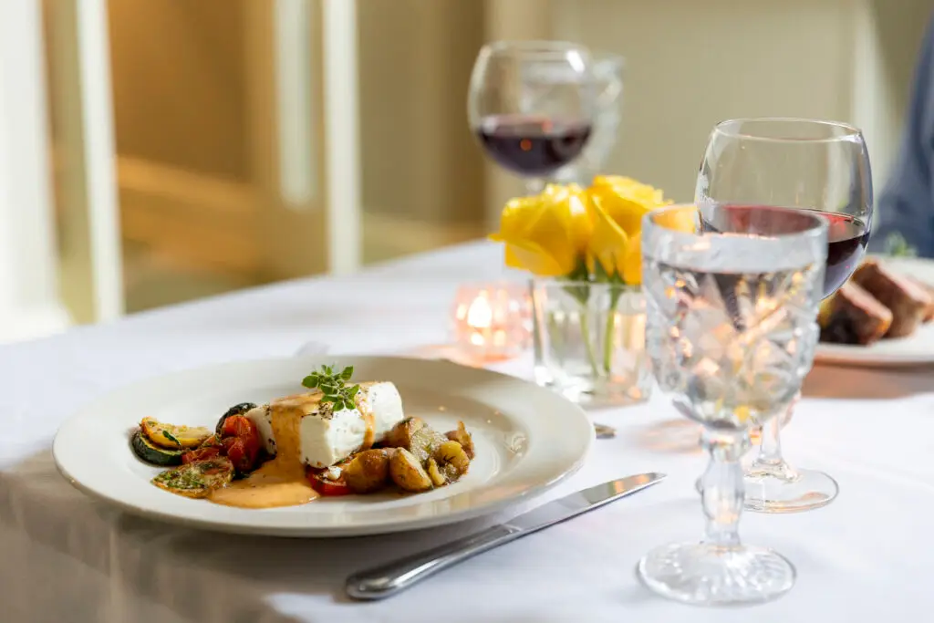 delicious fish plated on white table cloth with wine